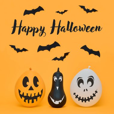 Şirin Halloween pumpkins komik yüzler ve turuncu arka plan üzerinde uçan kağıt yarasalar gülümseyen. Cadılar Bayramı kavramı.