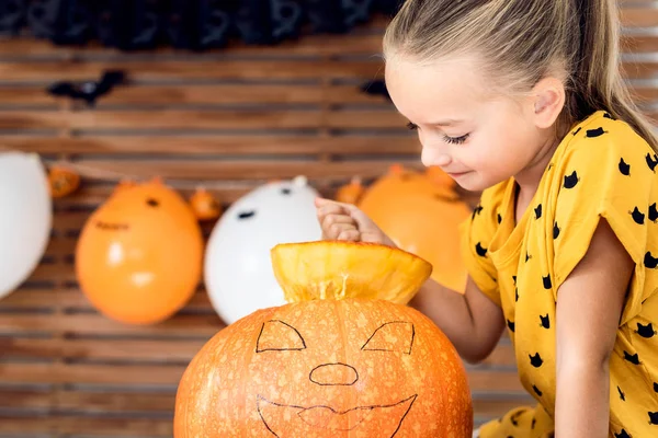 Nettes Kleines Mädchen Das Küchentisch Sitzt Und Einen Großen Kürbis — Stockfoto