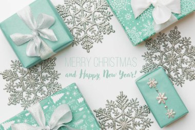 Güzel Noel hediyeleri ve beyaz arka plan üzerinde izole gümüş kar tanesi. Turkuaz renkli xmas kutuları sarılmış. Hediye sarma kavramı.