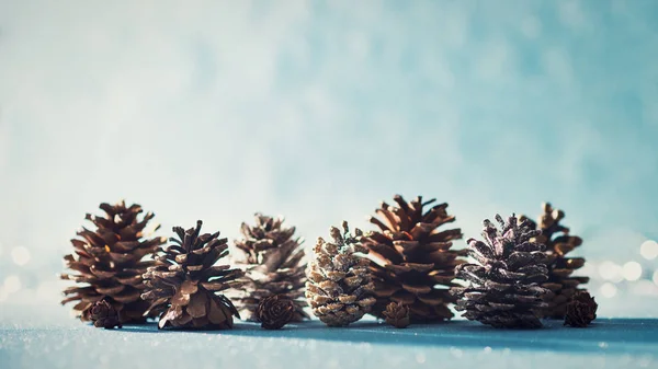 Mooie Kerstmis Achtergrond Dennenappels Glanzende Blauwe Achtergrond Met Intreepupil Kerstverlichting — Stockfoto