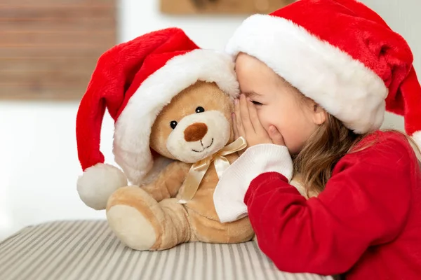 Cute Young Girl Wearing Santa Hat Whispering Secret Her Teddy — Stock Photo, Image