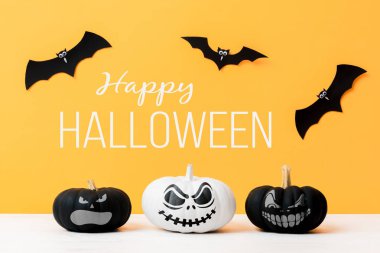 Üç korkunç Siyah ve Beyaz Jack o Fenerler ve sarı arka plan üzerinde uçan kağıt yarasalar. Cadılar Bayramı arka plan.