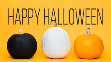 Turuncu arka plan üzerinde yan yana üç büyük Halloween kabaklar. Cadılar Bayramı tebrik kartı.