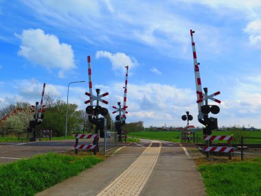 Uyarı lambaları ve kırmızı ve beyaz demiryolu geçişi Hollanda'da, engelleri
