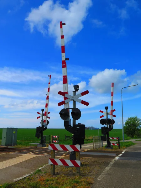 Uyarı lambaları ve kırmızı ve beyaz demiryolu geçişi Hollanda'da, engelleri