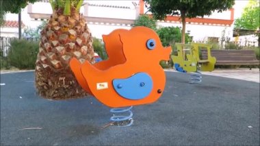 Alora, İspanya - 25 Ağustos 2018: Endülüs köyünde ağır baharda sallanan turuncu oyun alanı ördeği