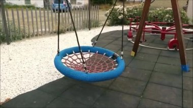 Endülüs köyündeki çocuk parkında büyük boş perdeli koltuk sallanıyor.