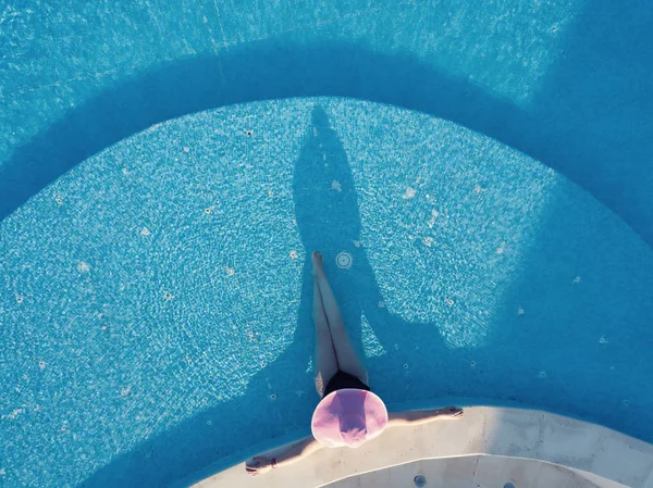 Jonge vrouw zonnebaden in een zwembad — Stockfoto