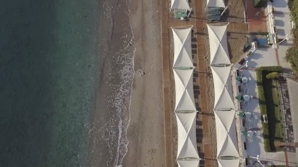 Imágenes aéreas de la costa con sombrillas en la playa de arena — Vídeos de Stock