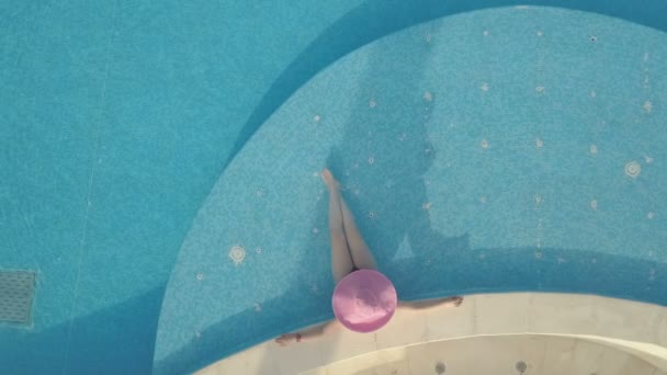 Νεαρή γυναίκα χαλαρώνοντας στην πισίνα — Αρχείο Βίντεο