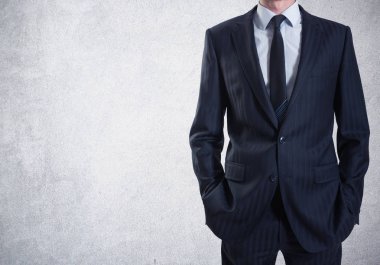 Beton duvar arka plan üzerinde takım elbiseli bir adam