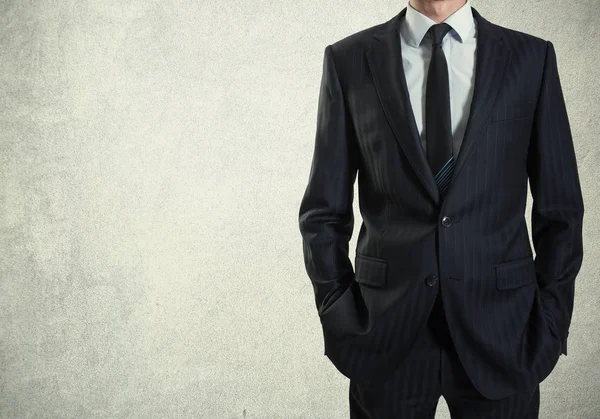 Beton duvar arka plan üzerinde takım elbiseli bir adam
