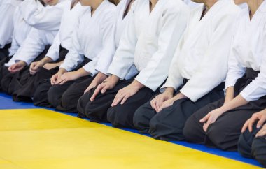 Kimono ve hakama giymiş insanlar dövüş sanatları eğitimi alıyorlar.