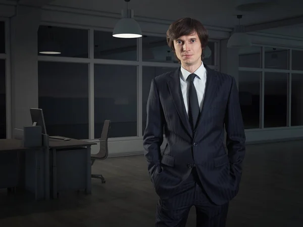 Ένας επιχειρηματίας που στέκεται στο γραφείο το βράδυ — Φωτογραφία Αρχείου