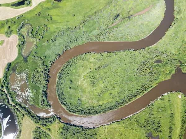 Aerial landscape of winding river in green fields