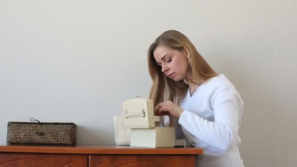 Schöne blonde Frau auf der Suche nach etwas in Schmuckschatullen, die neben einer Kommode stehen — Stockvideo