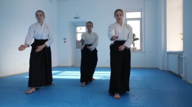 Üç kız siyah hakama Aikido hareketleri dövüş sanatları eğitimi üzerinde pratik