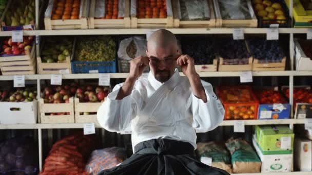 Un hombre en el fondo con estantes con frutas y verduras — Vídeos de Stock