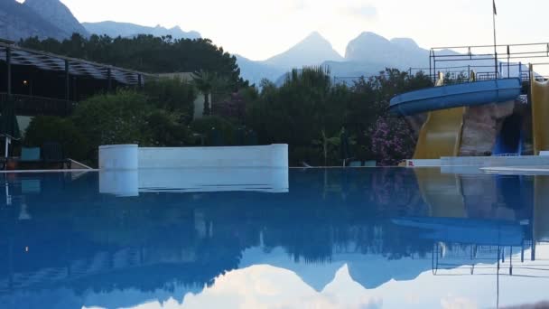 日落时酒店内的带水滑梯的游泳池 — 图库视频影像