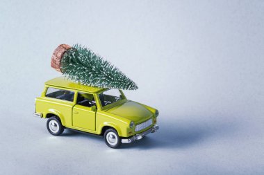 Üzerinde Noel ağacı olan minyatür yeşil araba en üstte.