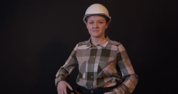Eine Bauarbeiterin Mit Weißem Schutzhelm Lächelt Auf Schwarzem Hintergrund — Stockvideo