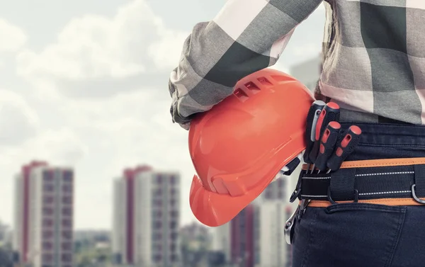 Una mujer trabajadora de la construcción con casco blanco sobre fondo de ciudad — Foto de Stock