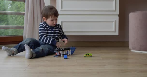 Toddler chłopiec bawi się samochodami domu — Wideo stockowe