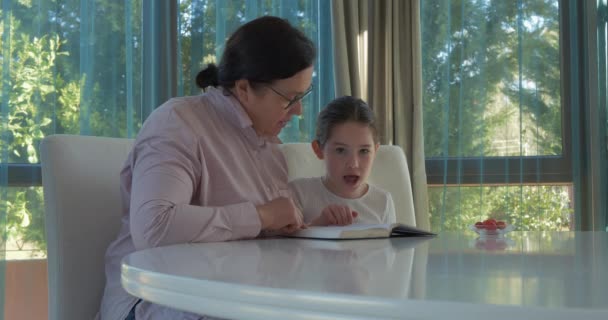 Büyükanne ve torun kitap okuyor. — Stok video