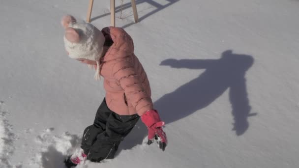 Beautiful little girl making a snow angel — Stock Video