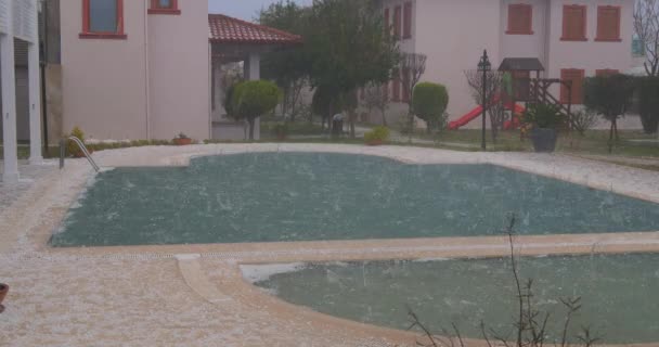 Hagel im Sommergewitter. Eiskugeln treffen Schwimmbad schwer — Stockvideo