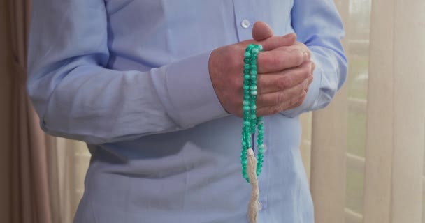 Les mains priantes d'un vieil homme avec des perles de chapelet — Video