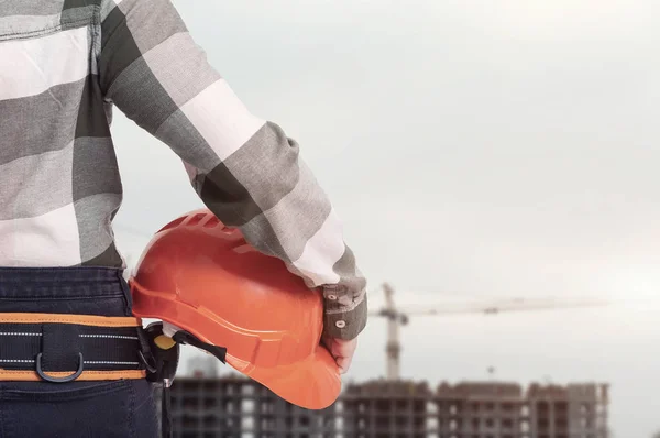 Una mujer trabajadora de la construcción con casco de seguridad contra el fondo de la ciudad — Foto de Stock