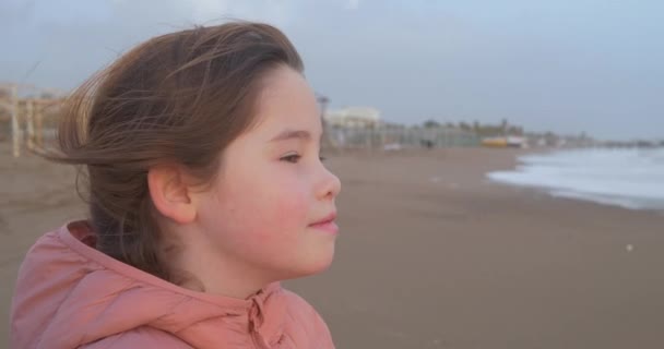 Een portret van een meisje die permanent op het strand in de winter — Stockvideo