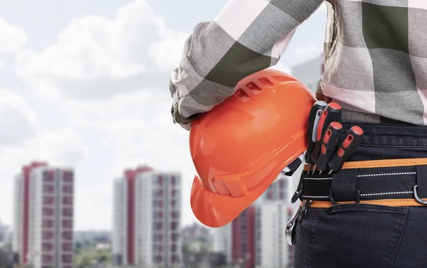 Uma trabalhadora da construção com capacete de segurança contra fundo da cidade — Fotografia de Stock