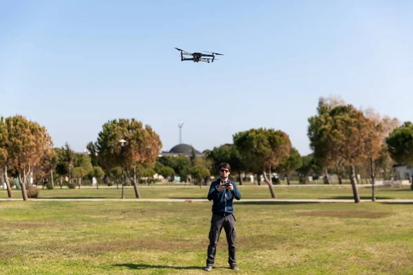Mężczyzna pilotując drona w parku w okresie wiosenno-letnim — Zdjęcie stockowe