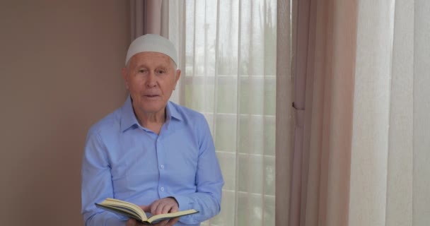 Een oude moslim man lezen van de Koran — Stockvideo