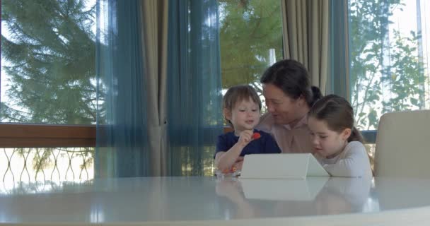 Büyükanne küçük torunlarını bir tablet bilgisayar oyunu ile eğlenceli — Stok video