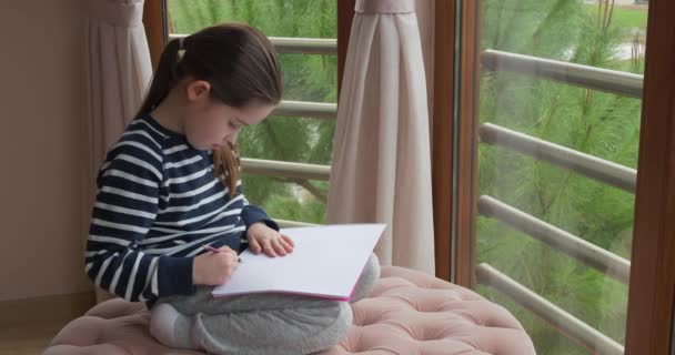 Ένα κορίτσι προσχολικής ηλικίας ζωγραφίζει με μολύβια στο σπίτι. — Αρχείο Βίντεο