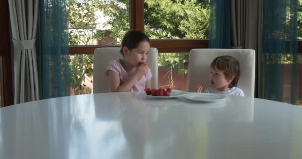 Leuke kinderen die thuis verse rijpe aardbeien eten — Stockvideo