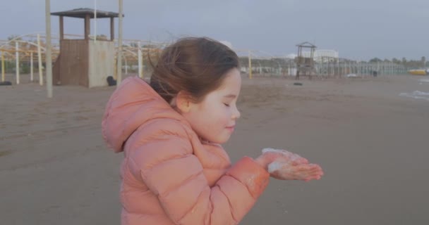 Портрет девушки, стоящей на пляже зимой — стоковое видео