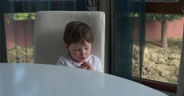 Leuke jongen eet verse rijpe aardbeien thuis — Stockvideo