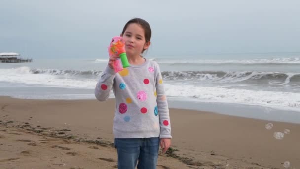 Dziecko robi pęcherzyki mydła grając na morzu. Aktywność na świeżym powietrzu na plaży dla dzieci — Wideo stockowe