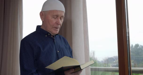Старый мусульманин, читающий Коран — стоковое видео