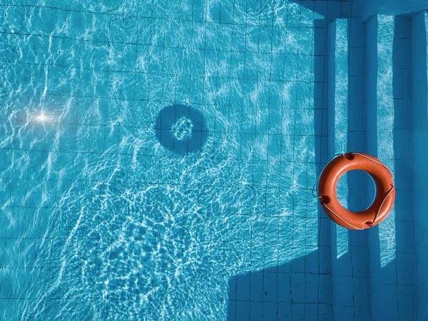 Boia salva-vidas laranja em uma piscina no verão — Fotografia de Stock