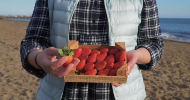 Frauenhände halten Holzkiste voller reifer Erdbeeren — Stockvideo