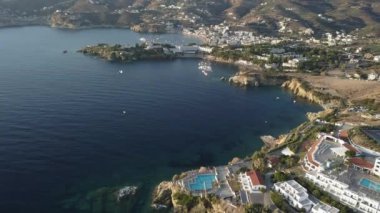Deniz kıyısında ki tepede bulunan otel ile güzel koy havadan drone görüntüleri