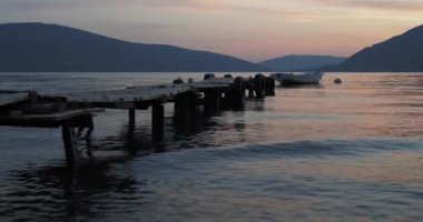 Akşamları denizde ahşap iskeleye bağlı bir tekne