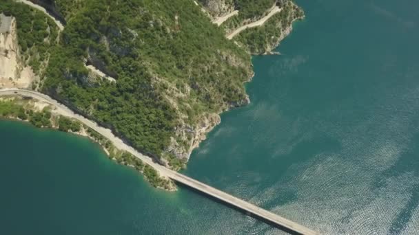 Imágenes aéreas de un coche conduciendo por un puente en el lago Piva — Vídeos de Stock