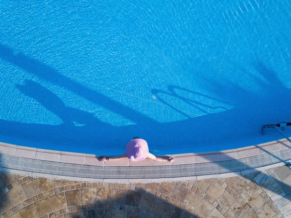 Νεαρή γυναίκα ηλιοθεραπεία σε μια πισίνα — Φωτογραφία Αρχείου