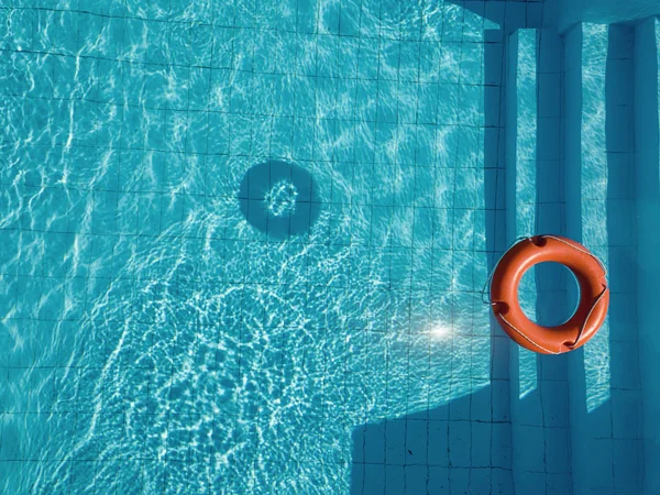 Boia salva-vidas laranja em uma piscina no verão — Fotografia de Stock